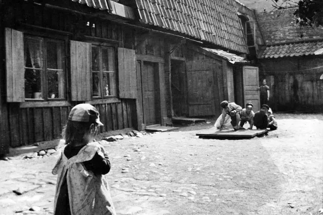 Children playing in a backyard. Old black and white photo.