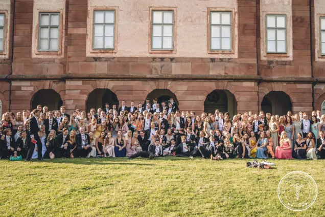 Big group of people in ballroom clothes standing in the sun. Photo.