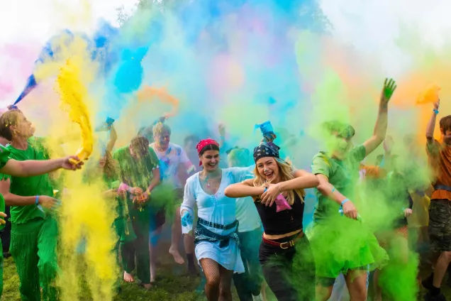 Happy students in coloured smoke. Photo. 