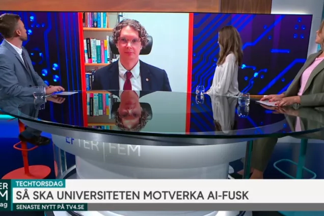 Björn Svensson is projected on a screen between three hosts during a TV broadcast. 