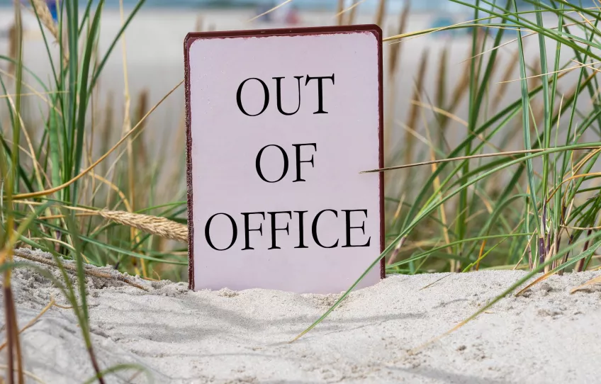A photo of a sign on a sandy beach.